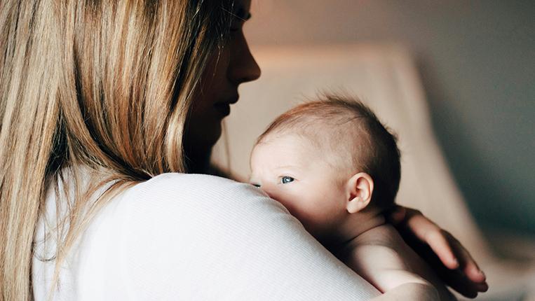 Uma mãe com um bebé ao colo